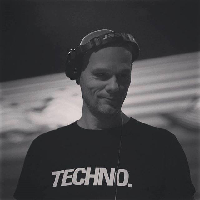 Rick Dyno met zijn koptelefoon op en een zwart t-shirt met het woord Techno. er op.